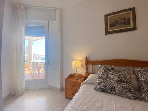 a bedroom with a bed and a door to a balcony at Talima in Calpe