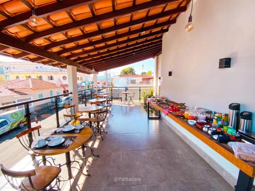 a restaurant with tables and chairs on a balcony at Pousada Reserva Central in Capitólio