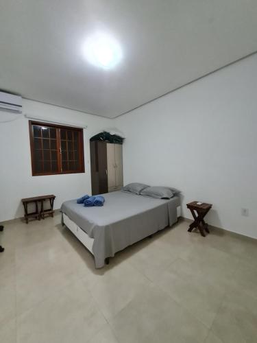 een slaapkamer met een bed in een witte kamer bij Apartamento lençóis 103 in Lençóis