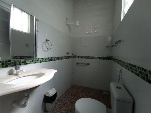 タイーバにあるCasa dos Ximenes - Beira Mar da Taíba - Ótima localizaçãoの洗面台、トイレ、鏡のあるバスルーム