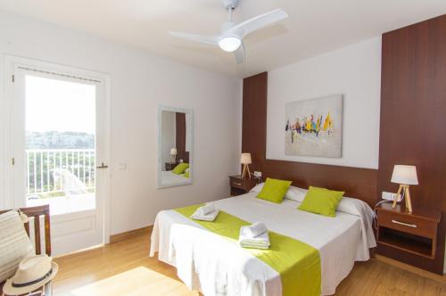 a bedroom with a large bed with green pillows at Casa Febrer by Sonne Villas in Cala Galdana