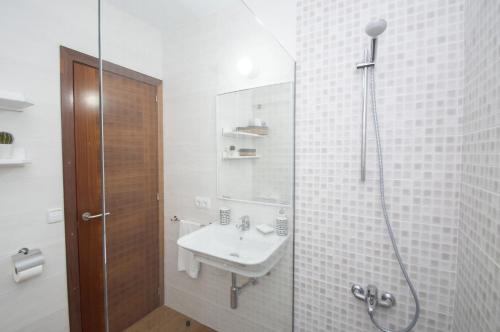 a white bathroom with a shower and a sink at Casa Febrer by Sonne Villas in Cala Galdana