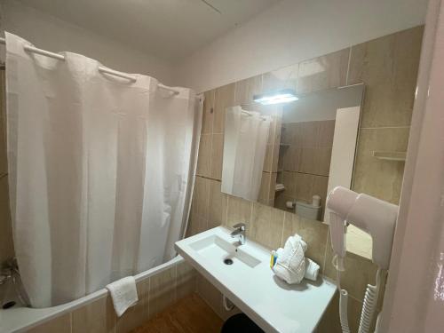 y baño con lavabo y ducha con espejo. en Apartamentos Los Tarajales, en Valle Gran Rey
