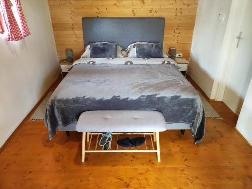 a bedroom with a large bed with a blue comforter at Pod orehom drvena kuća i sauna in Krapina