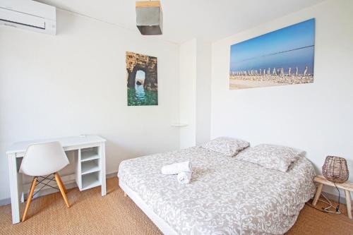 une chambre blanche avec un lit et un bureau dans l'établissement Duplex toit terrasse vue panoramique, à Montpellier