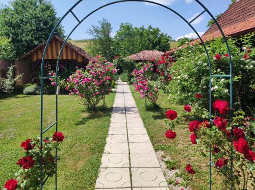 a path through a garden with roses at Pod orehom drvena kuća i sauna in Krapina