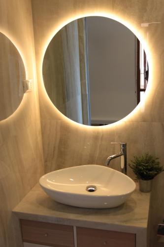 Un baño con un lavabo blanco y un espejo. en Appartamento Fronte Mare Sottomarina, en Sottomarina