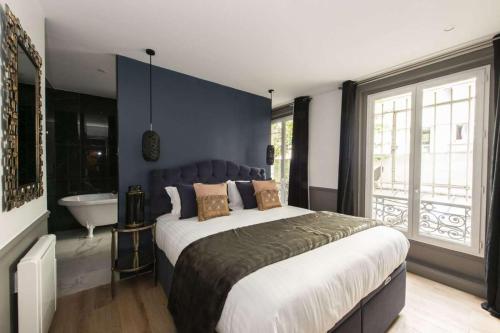 a bedroom with a large bed and a tub and a sink at Marianne in Paris