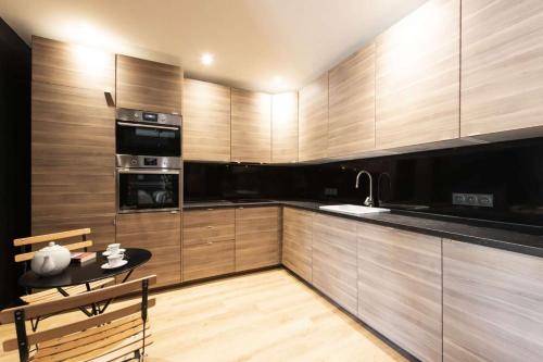 - une cuisine avec des placards en bois, une table et un évier dans l'établissement Marianne, à Paris