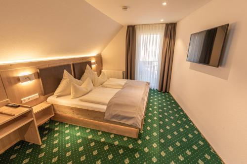 a hotel room with a bed and a television at Landhaus Lauble in Hornberg