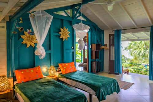 2 camas en una habitación con paredes azules en TropicAngel ECOLODGE de Charme, en Pointe-Noire