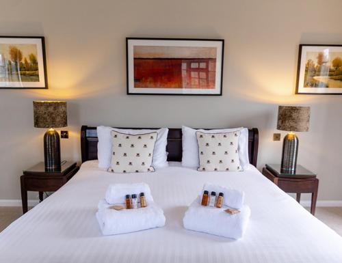 a bedroom with a white bed with two night stands at The Bell Inn Hotel in Lyndhurst