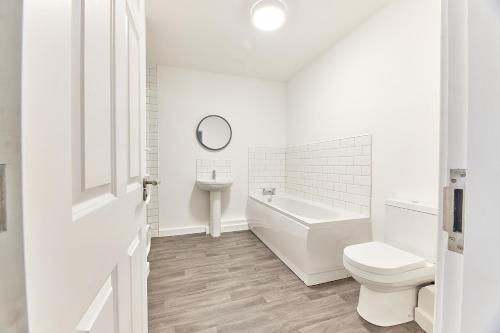 e bagno bianco con vasca, servizi igienici e lavandino. di Low Lights - Properties Unique a North Shields