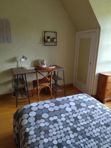 - une chambre avec un lit, une table et un bureau dans l'établissement Chambre Solo Grande maison, à Gouesnou