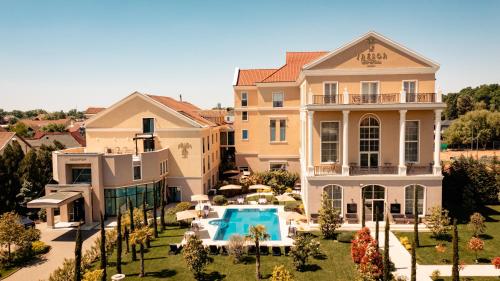 uma casa grande com uma piscina em frente em Hotel Tresor Le Palais em Timisoara