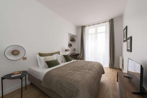une chambre avec un grand lit et une fenêtre dans l'établissement Martin' s Door, à Paris