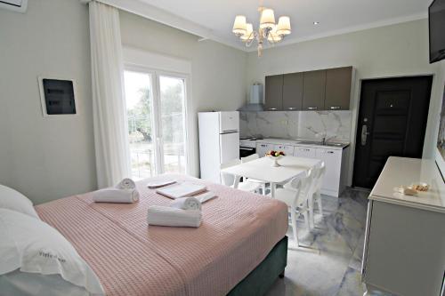 a bedroom with a bed and a kitchen with a table at Olga's Suite Al Mar in Skala Kallirakhis