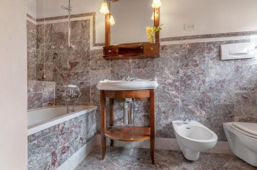 ein Badezimmer mit einem Waschbecken, einer Badewanne und einem WC in der Unterkunft Fattoria la Gigliola - La Terrazza in Montespertoli