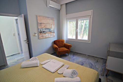 a room with a bed and a chair and a window at Olga's Suite Al Mar in Skala Kallirakhis