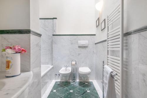 a white bathroom with a toilet and a sink at Fattoria la Gigliola - Il Fattore in Montespertoli