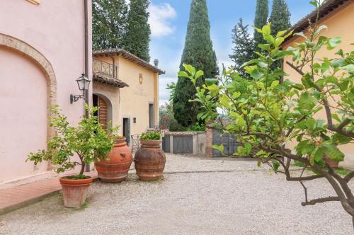 a group of potted plants sitting next to a building at Fattoria la Gigliola - Il Fattore in Montespertoli