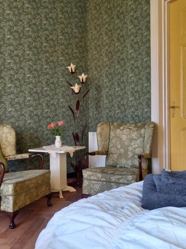 - une chambre avec un lit, deux chaises et une table dans l'établissement B&B Villa de Beuk, à Stadskanaal