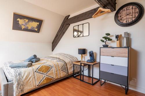 sypialnia z łóżkiem i zegarem na ścianie w obiekcie Heaven - GOLDEN TREE - WIFI - 20 min St-Croix & Center Parcs w mieście Sarrebourg