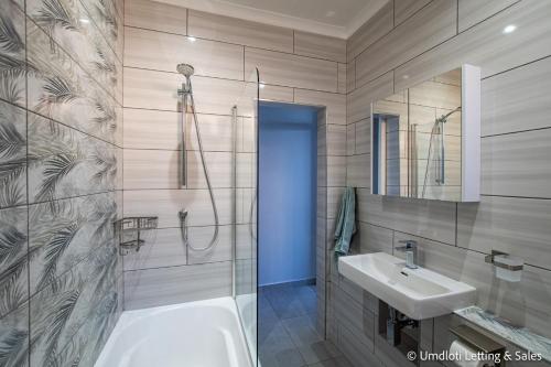 a bathroom with a tub and a sink and a shower at Twin Tide Duplex in Umdloti