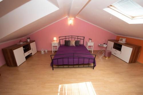 - une chambre mansardée avec un lit violet dans l'établissement Kuća za odmor Ivanka, à Vodnjan