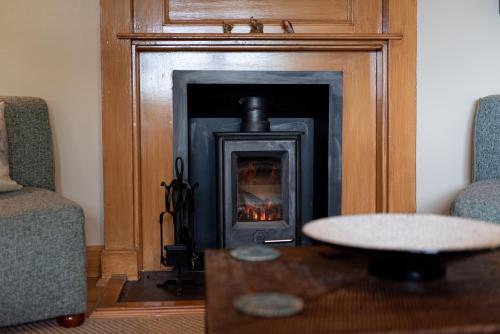 a fireplace in a living room with a fire place at Steading Cottage - 50m from the beach in Port Appin