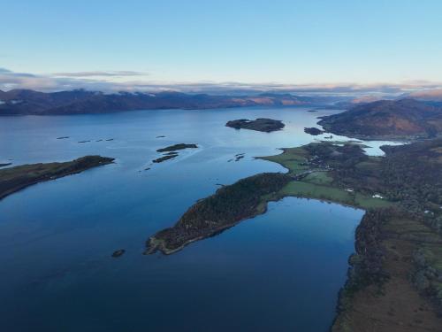 an island in the middle of a body of water at Steading Cottage - 50m from the beach in Port Appin