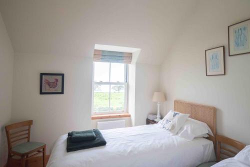 a bedroom with two beds and a window at Steading Cottage - 50m from the beach in Port Appin