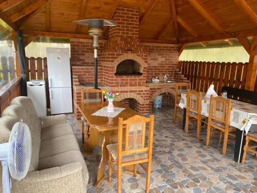 a kitchen with a table and chairs and a brick oven at Casa Alexia in Haţeg