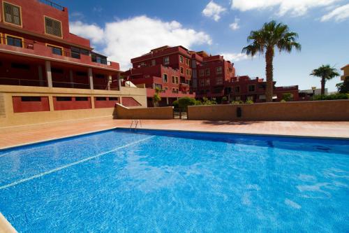 une grande piscine bleue à côté de certains bâtiments dans l'établissement MEDANO4YOU Mirandas Choice Penthouse, à El Médano