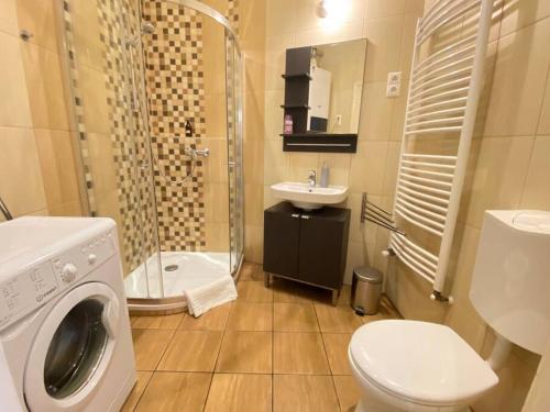 uma casa de banho com um WC, um lavatório e uma máquina de lavar roupa em ORANGEHOMES One Bedroom Comfy Apartment em Budapeste