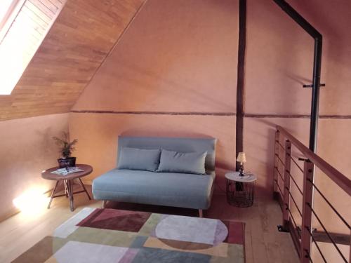 une chambre avec un canapé bleu et une table dans l'établissement Gite La Granica, à Bosset