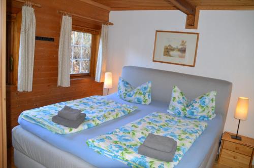 Schlafzimmer mit einem Bett mit blauer Bettwäsche und Kissen in der Unterkunft Eifelcottage in Ulmen