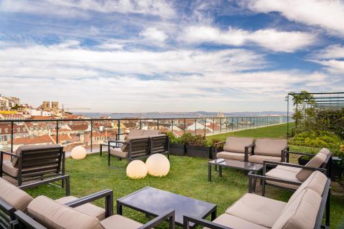 a patio with furniture and a view of the city at Hotel do Chiado in Lisbon