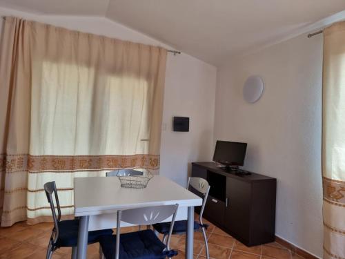 a small room with a white table and a computer at Residenze Pedrame in Budoni