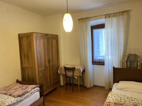 een slaapkamer met een bed, een tafel en een raam bij Trilocale 020 Pinzolo in Pinzolo