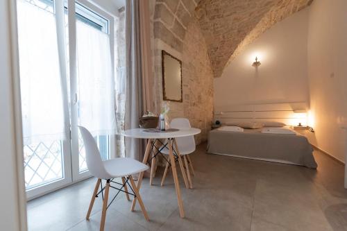 a room with a bed and a table and chairs at Il Saraceno Apartment in Giovinazzo