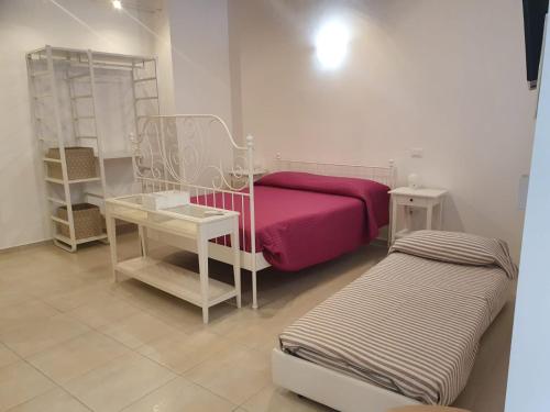 a room with a bed and a table and a shelf at La piccola dimora in Ortona