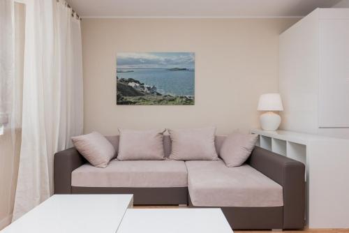 - un salon avec un canapé et une vue sur l'océan dans l'établissement Zdrojowa Apartments, à Świnoujście