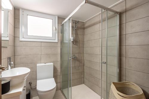 a bathroom with a shower and a toilet and a sink at Arty Haven - Spacious 3-BR House in Larnaca in Larnaka