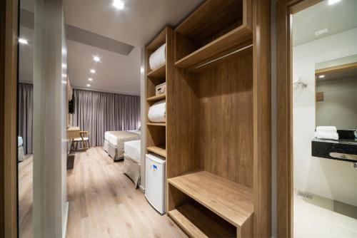 a room with a bedroom with a bed and a closet at Hotel Laghetto Fratello in Gramado
