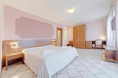 ein Schlafzimmer mit einem großen weißen Bett in einem Zimmer in der Unterkunft Hotel Grotto Bagat in Lavena Ponte Tresa