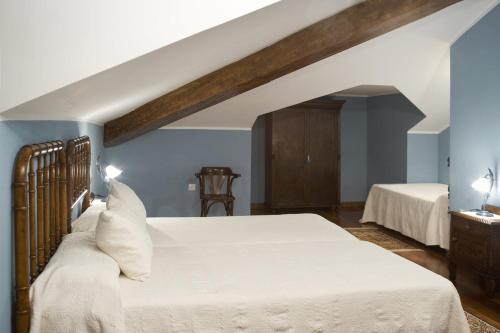 a bedroom with two beds and blue walls at La Casona de la Roza in Valbucar
