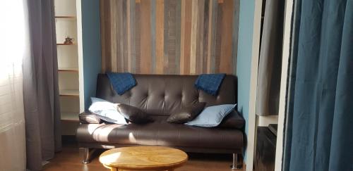 a brown leather couch with pillows in a living room at Soldeu Paradis Tarter Baix in El Tarter