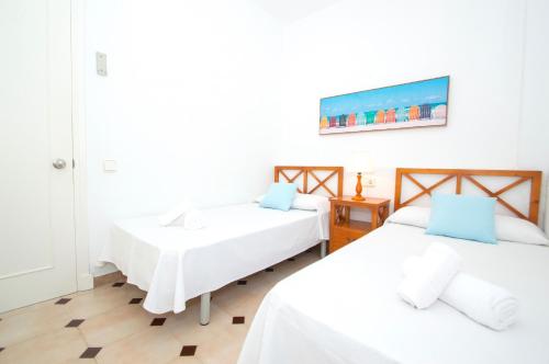 a bedroom with two beds and a painting on the wall at Villa Alzina by Sonne Villas in Cala Galdana