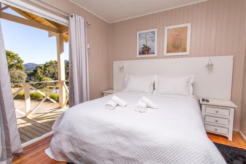 a bedroom with a bed with two slippers on it at Pousada Pedra Preta in Urubici